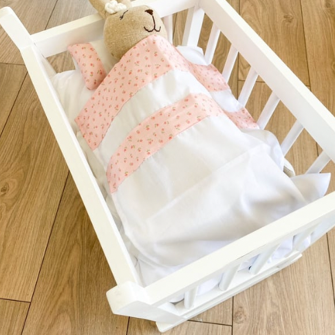 muñeca en cuna de madera de keiki